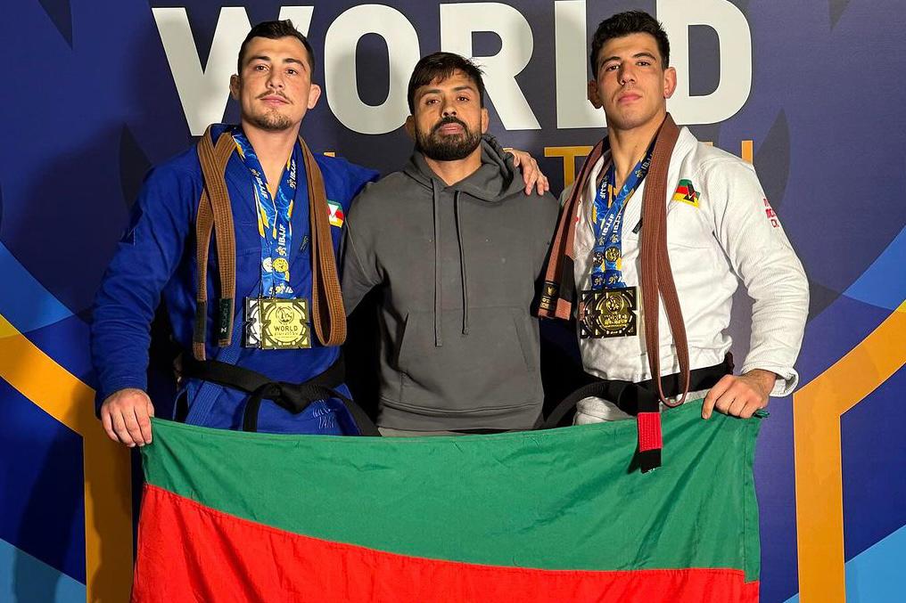 Leo Ferreira, Mario Reis e Robson No Brake com a bandeira do RS no pódio do Mundial 2024. Foto: IBJJF