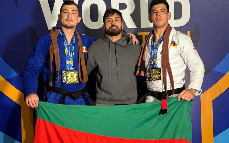 Leo Ferreira, Mario Reis e Robson No Brake com a bandeira do RS no pódio do Mundial 2024. Foto: IBJJF