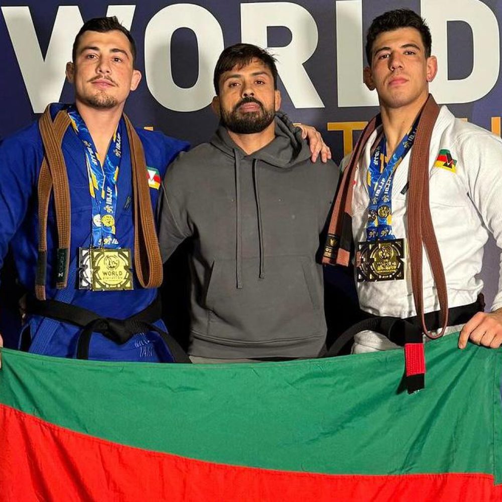 Leo Ferreira, Mario Reis e Robson No Brake com a bandeira do RS no pódio do Mundial 2024. Foto: IBJJF